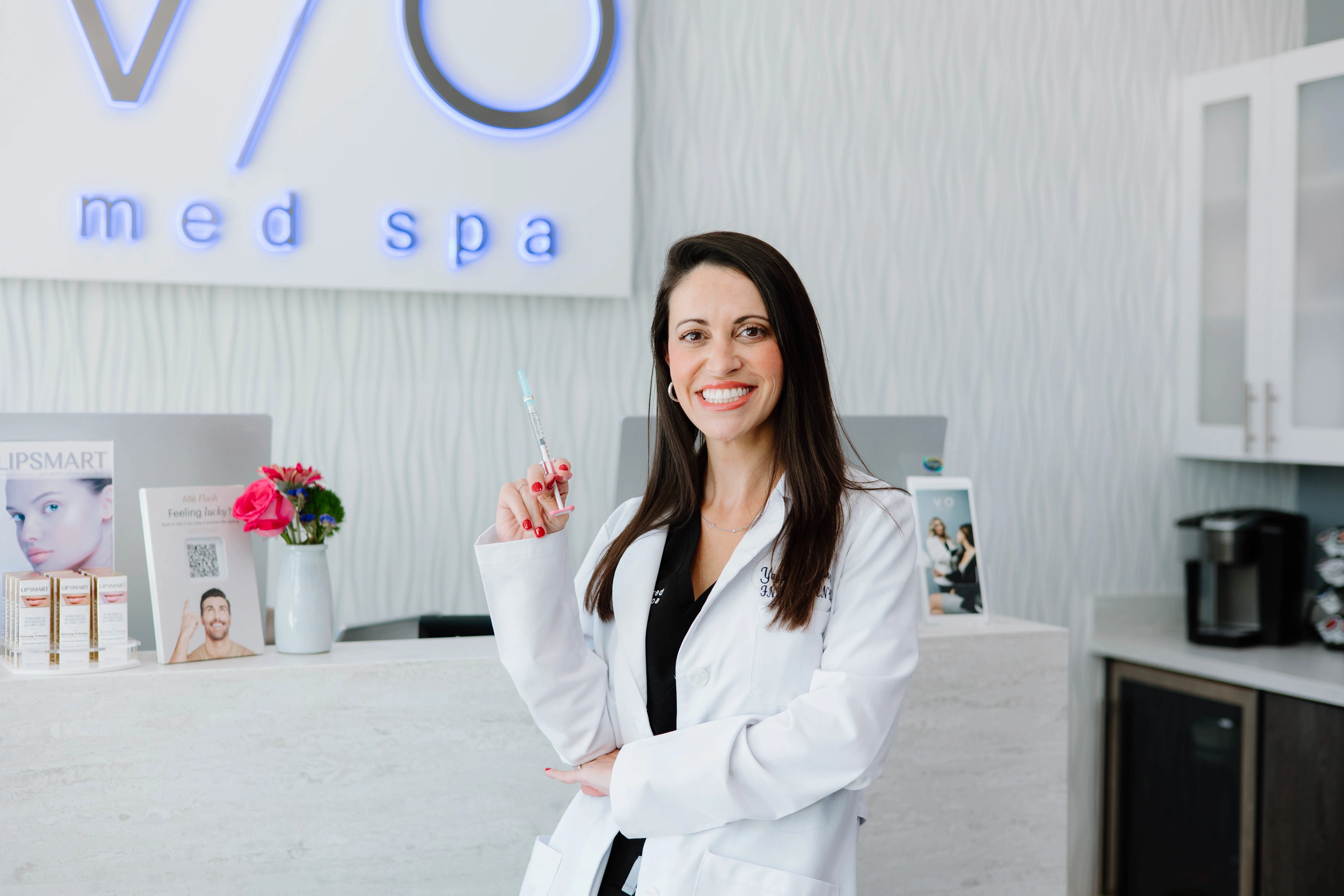 VIO Med Spa provider holding an injectable syringe at the front desk